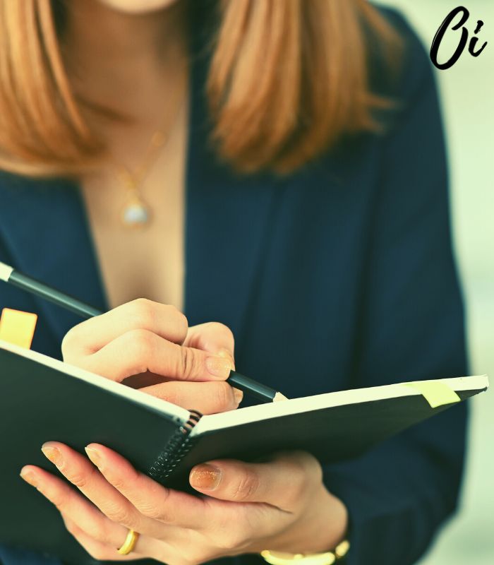 A lady jotting down notes in a meeting.