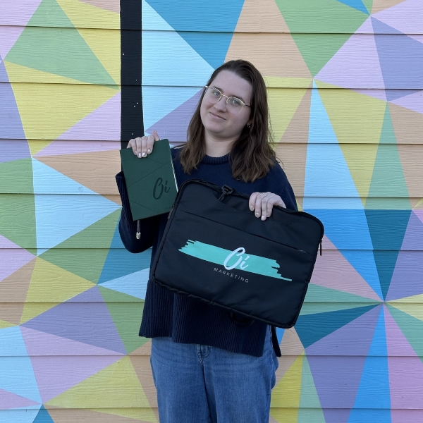 Woman holding marketing materials against colorful geometric wall | GPS: 49.353109, -122.517248